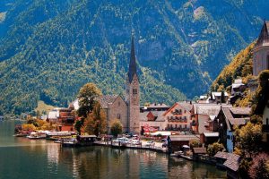 Travel Time | Best Europe Holiday Packages for 2026: Complete Travel Guide Scenic lakeside village with a historic church, alpine mountains, and charming waterfront homes in Hallstatt.