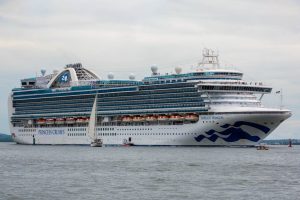 Princess Cruises cruise ship sailing on calm waters under an overcast sky.